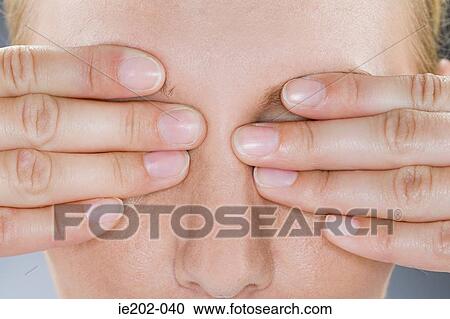 A woman covering her eyes View Large Photo Image Stock Image - A woman covering her eyes. Fotosearch