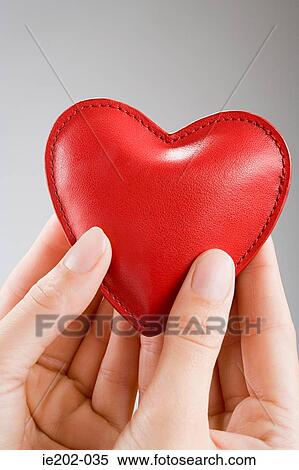 A woman holding a heart cushion View Large Photo Image Stock Photography - A woman holding a heart cushion. Fotosearch