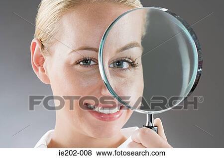A woman holding a magnifying glass View Large Photo Image Stock Photo - A woman holding a magnifying glass. Fotosearch
