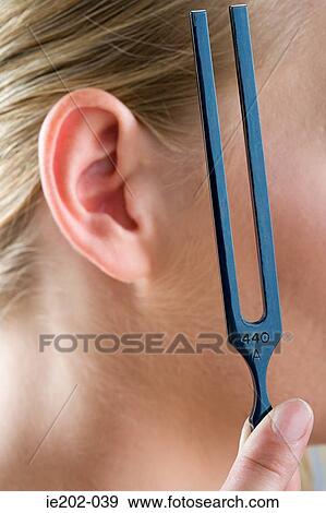 A woman holding a tuning fork View Large Photo Image Stock Photo - A woman holding a tuning fork. Fotosearch