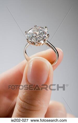 A woman holding an engagement ring View Large Photo Image Stock Photo - A woman holding an engagement ring. Fotosearch