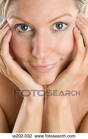 A woman touching her face View Large Photo Image Stock Image - A woman touching her face. Fotosearch