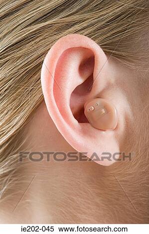 A woman wearing a hearing aid View Large Photo Image Stock Photography - A woman wearing a hearing aid. Fotosearch