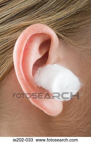 Stock Image - A woman with cotton wool in her ears. Fotosearch