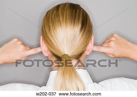 Stock Photo - A woman with her fingers in her ear. Fotosearch