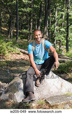 Man sitting on a rock View Large Photo Image Stock Photo - Man sitting on a rock. Fotosearch