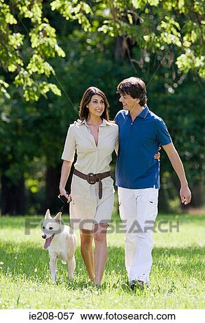 Stock Photo - Couple walking dog. Fotosearch