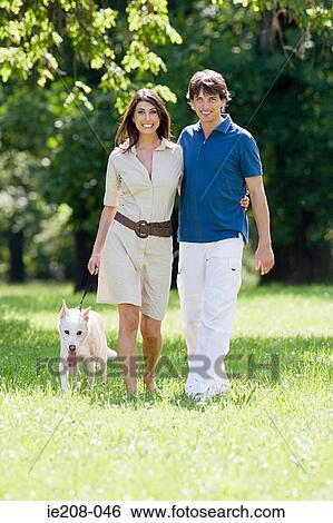 Couple walking dog View Large Photo Image Stock Photograph - Couple walking dog. Fotosearch
