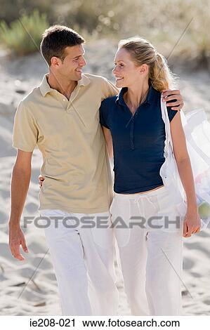 Stock Image - Couple walking on beach. Fotosearch