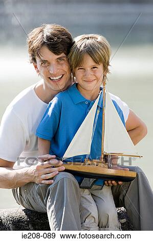 Father and son with toy boat View Large Photo Image Stock Photo - Father and son with toy boat. Fotosearch
