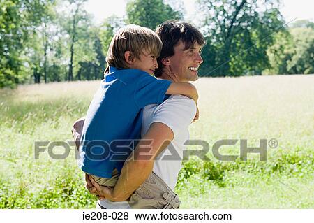 Father giving son a piggyback View Large Photo Image Stock Photo - Father giving son a piggyback. Fotosearch