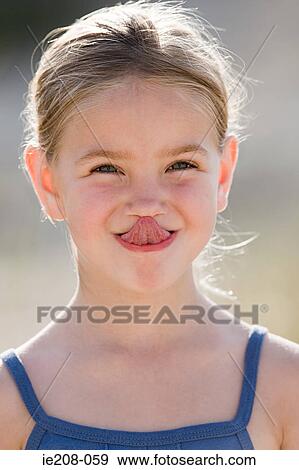 Girl touching nose with tongue View Large Photo Image Stock Photo - Girl touching nose with tongue. Fotosearch