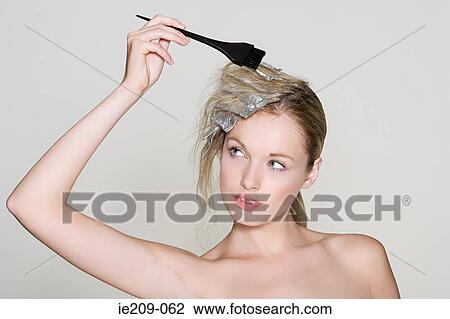A woman highlighting her hair View Large Photo Image Stock Image - A woman highlighting her hair. Fotosearch
