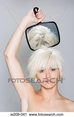 A woman holding a hand mirror View Large Photo Image Stock Image - A woman holding a hand mirror. Fotosearch