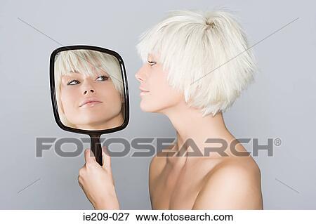 Stock Photo - A woman looking at her reflection. Fotosearch