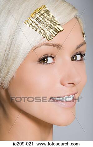 Stock Image - Portrait of a woman wearing hair clips. Fotosearch