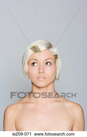 Stock Image - Portrait of a woman wearing hair clips. Fotosearch