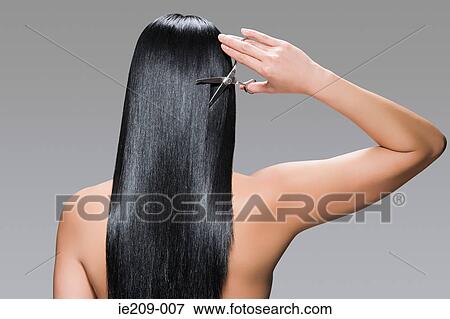 Rear view of a woman cutting her hair View Large Photo Image Stock Photo - Rear view of a woman cutting her hair. Fotosearch