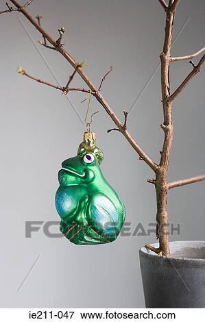 Stock Photo - Christmas bauble hanging off a bare tree. Fotosearch