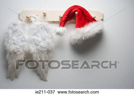 Wings and santas hat hanging on a hook View Large Photo Image Stock Photo - Wings and santas hat hanging on a hook. Fotosearch