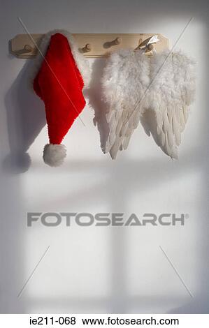Wings and santas hat hanging on a hook View Large Photo Image Stock Photo - Wings and santas hat hanging on a hook. Fotosearch