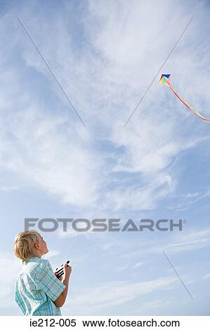 A boy flying a kite View Large Photo Image Stock Photography - A boy flying a kite. Fotosearch