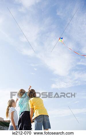 Children flying a kite View Large Photo Image Stock Image - Children flying a kite. Fotosearch
