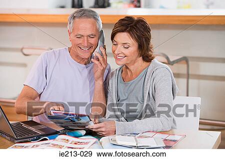 A couple looking at brochures View Large Photo Image Stock Photo - A couple looking at brochures. Fotosearch
