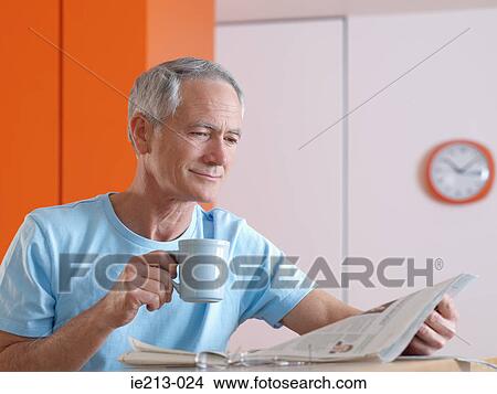 Picture - A man reading a paper. Fotosearch