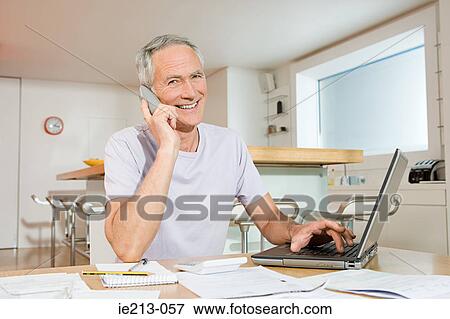 Stock Photo - A man sorting out his home finances. Fotosearch