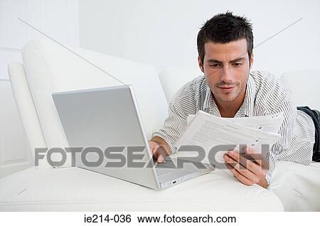 Man with bills and laptop View Large Photo Image Stock Photograph - Man with bills and laptop. Fotosearch
