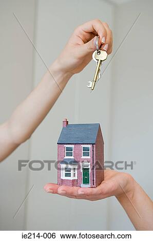 People holding keys and house View Large Photo Image Stock Photograph - People holding keys and house. Fotosearch