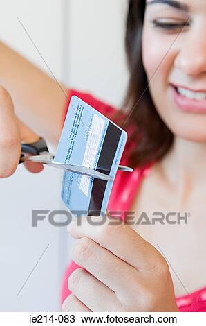 Stock Image - Woman cutting credit card. Fotosearch