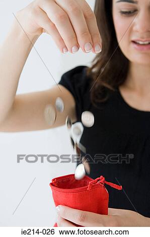 Woman dropping coins into purse View Large Photo Image Stock Photograph - Woman dropping coins into purse. Fotosearch