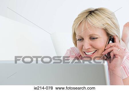 Woman with cellphone and laptop View Large Photo Image Stock Photo - Woman with cellphone and laptop. Fotosearch