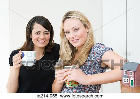 Women with coffee cups and model house View Large Photo Image Stock Photography - Women with coffee cups and model house. Fotosearch