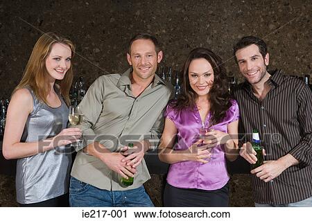 Stock Image - Friends drinking in a bar. Fotosearch