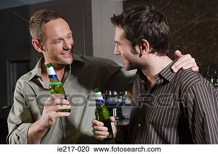 Stock Image - Two men drinking in a bar. Fotosearch