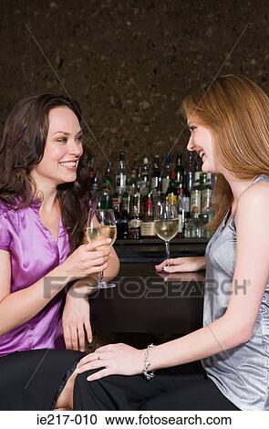 Stock Image - Two women drinking in a bar. Fotosearch