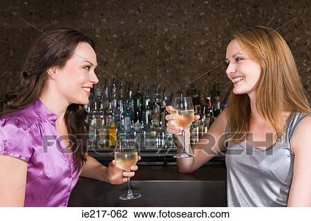 Two women drinking in a bar View Large Photo Image Stock Image - Two women drinking in a bar. Fotosearch
