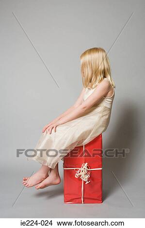 Picture - Girl sitting on a present. Fotosearch