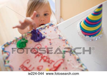 Girl touching birthday cake View Large Photo Image Picture - Girl touching birthday cake. Fotosearch