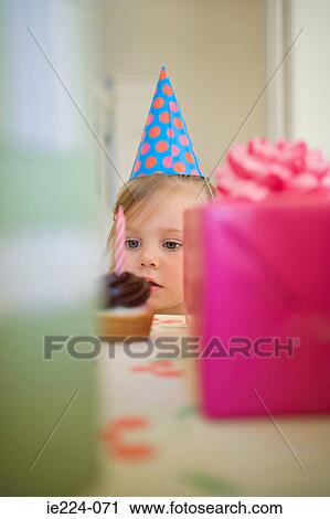 Stock Image - Little girl looking at cake. Fotosearch