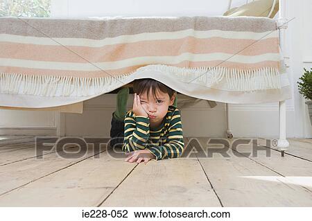 Boy hiding under a bed View Large Photo Image Stock Image - Boy hiding under a bed. Fotosearch