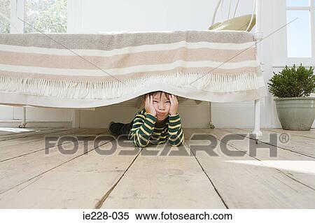 Boy hiding under a bed View Large Photo Image Stock Photography - Boy hiding under a bed. Fotosearch