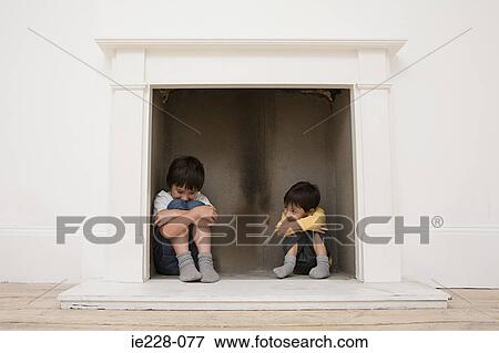 Boys hiding in a fireplace View Large Photo Image Stock Photo - Boys hiding in a fireplace. Fotosearch