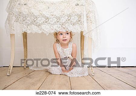 Girl hiding under a table View Large Photo Image Picture - Girl hiding under a table. Fotosearch