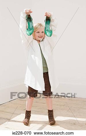 Girl holding a pair of heeled shoes View Large Photo Image Stock Image - Girl holding a pair of heeled shoes. Fotosearch