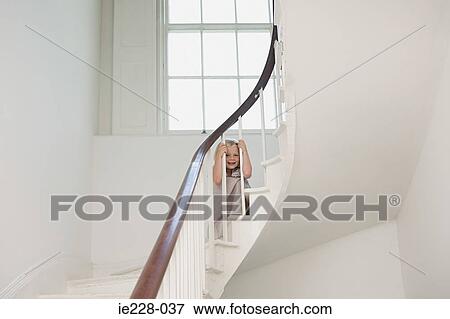 Girl Looking Through Banisters Stock Photo Ie228 037 Fotosearch