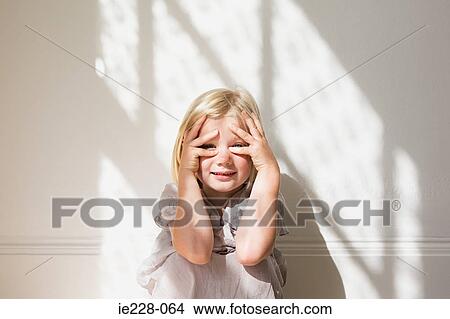 Girl peeking through her fingers View Large Photo Image Picture - Girl peeking through her fingers. Fotosearch
